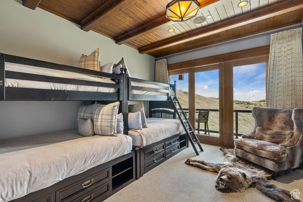 Bedroom featuring beamed ceiling, wooden ceiling, carpet flooring, and access to outside