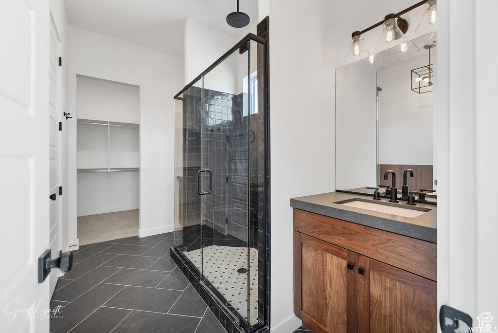 Bathroom with tile floors, an enclosed shower, and vanity