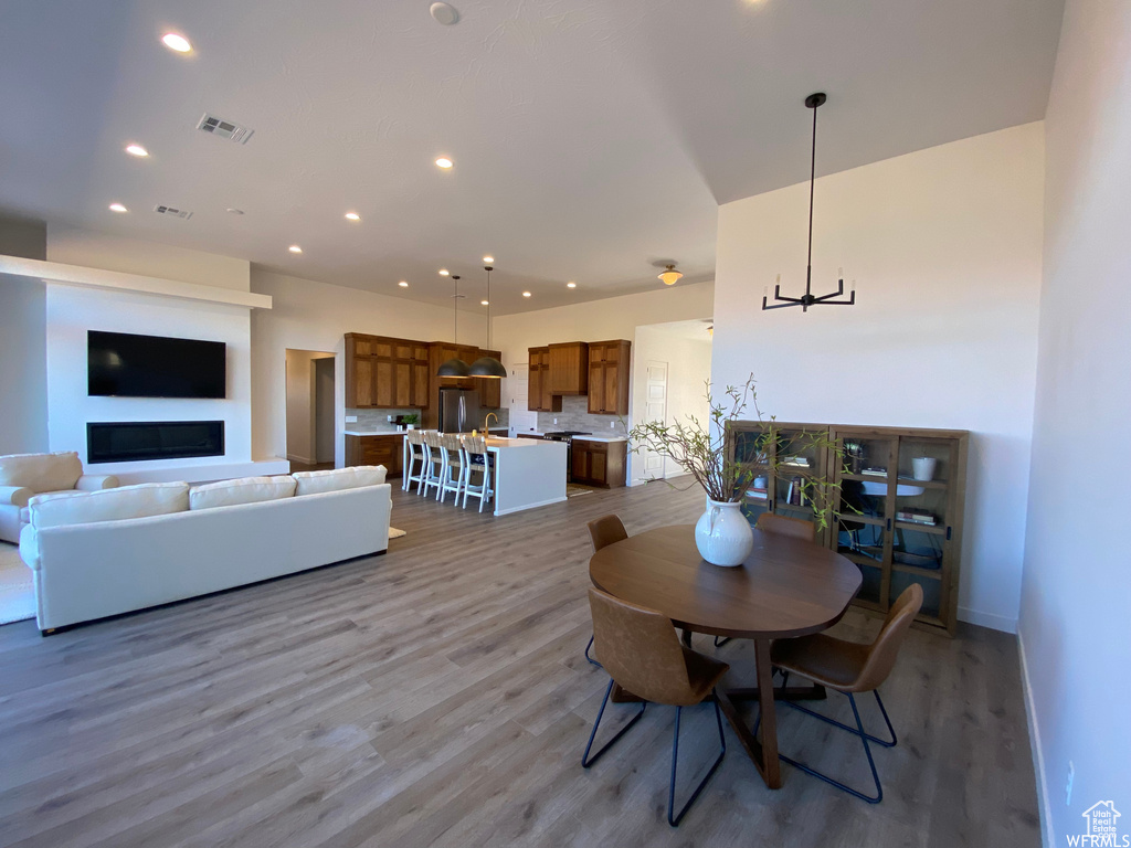 Dining room with light hardwood / wood-style floors and a notable chandelier