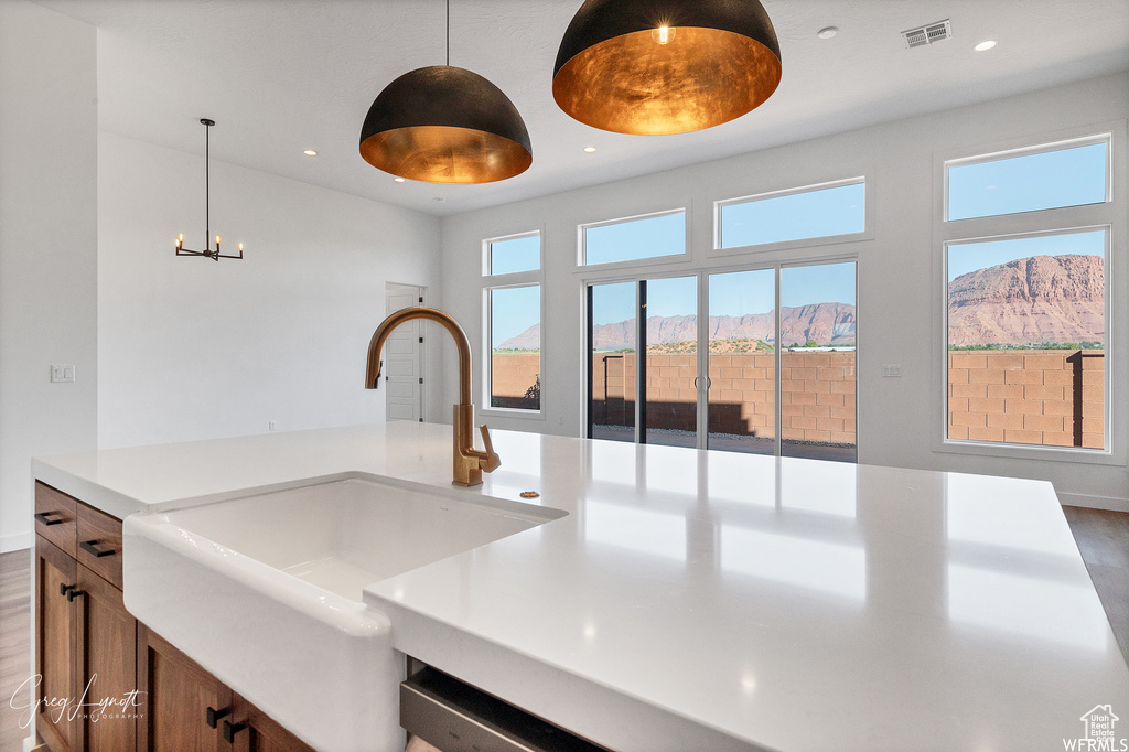 Kitchen with sink, wood-type flooring, a mountain view, and hanging light fixtures