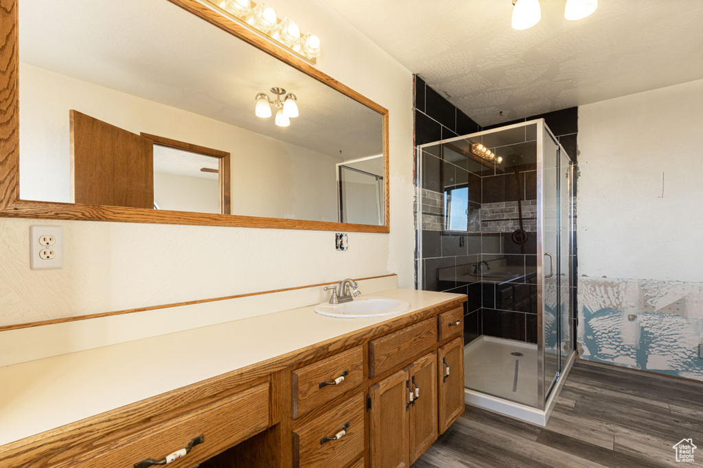 Bathroom featuring hardwood / wood-style floors, an enclosed shower, and vanity