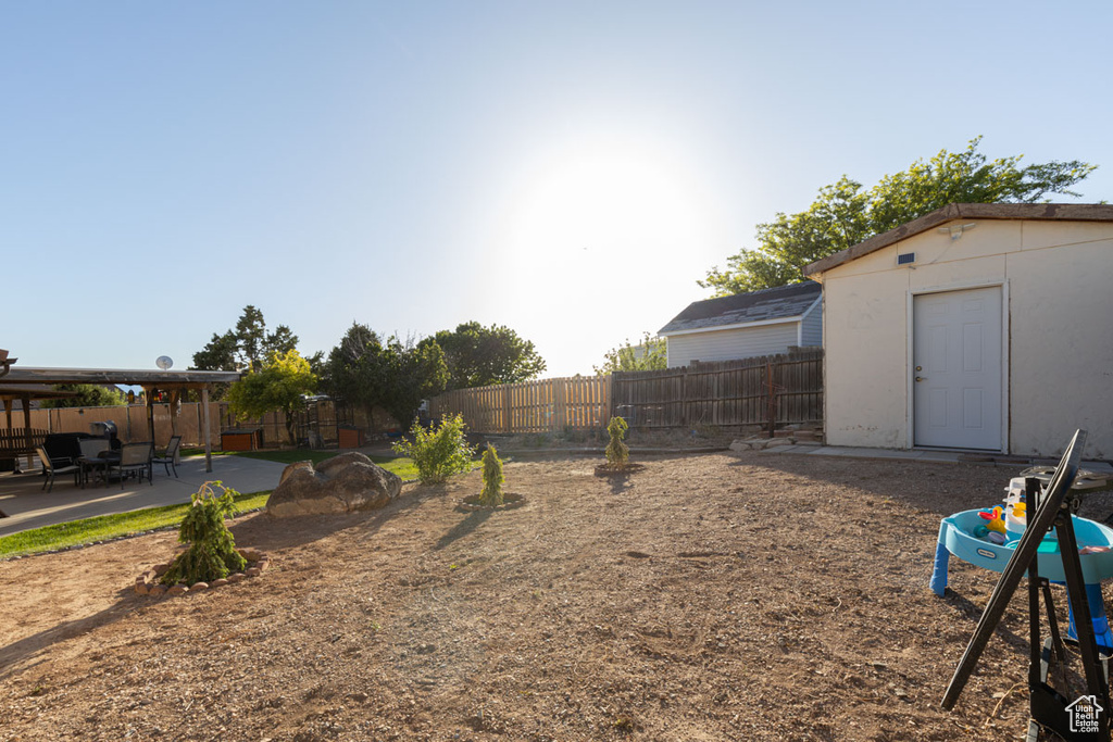 View of yard with a patio area and a storage unit