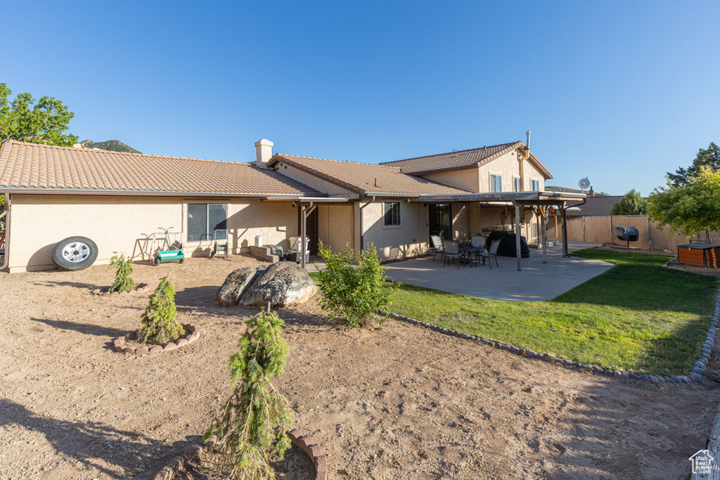 Back of house with a yard and a patio area