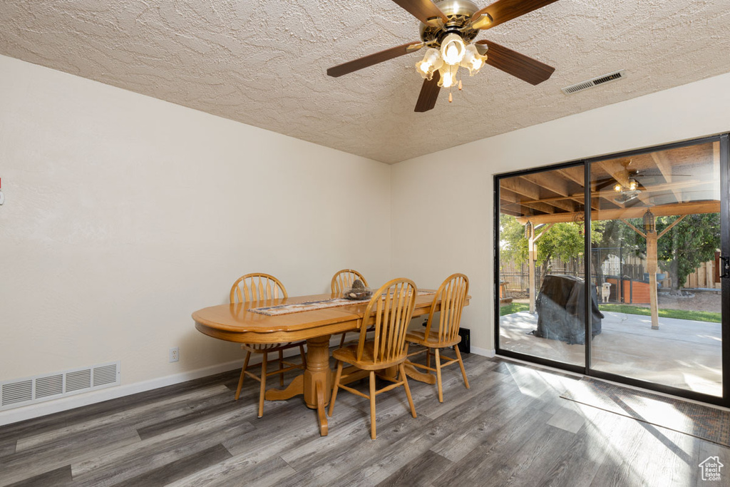 Dining area featuring a textured ceiling, ceiling fan, and dark hardwood / wood-style flooring