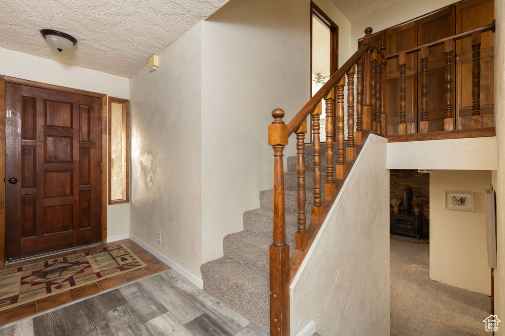 Foyer entrance featuring a textured ceiling and carpet