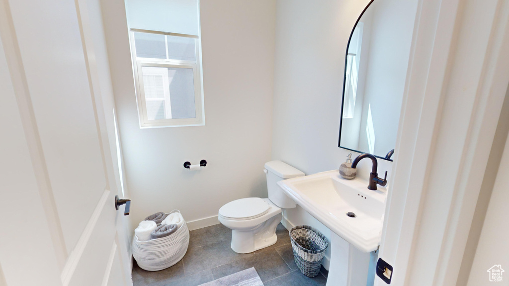 Bathroom featuring a healthy amount of sunlight, tile flooring, sink, and toilet