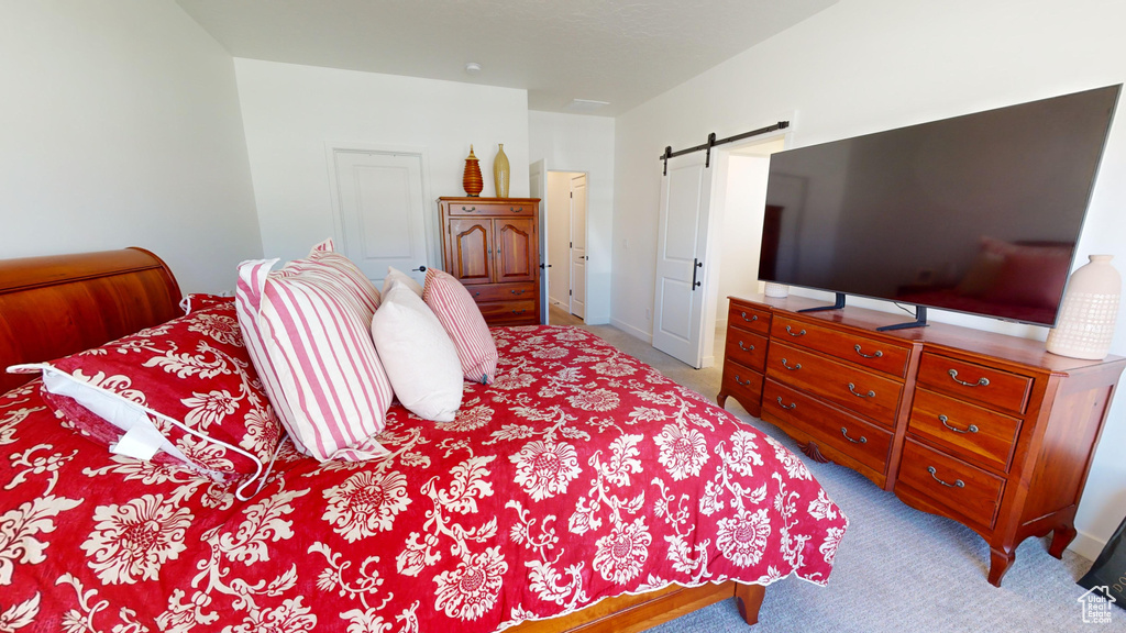 Carpeted bedroom featuring a barn door