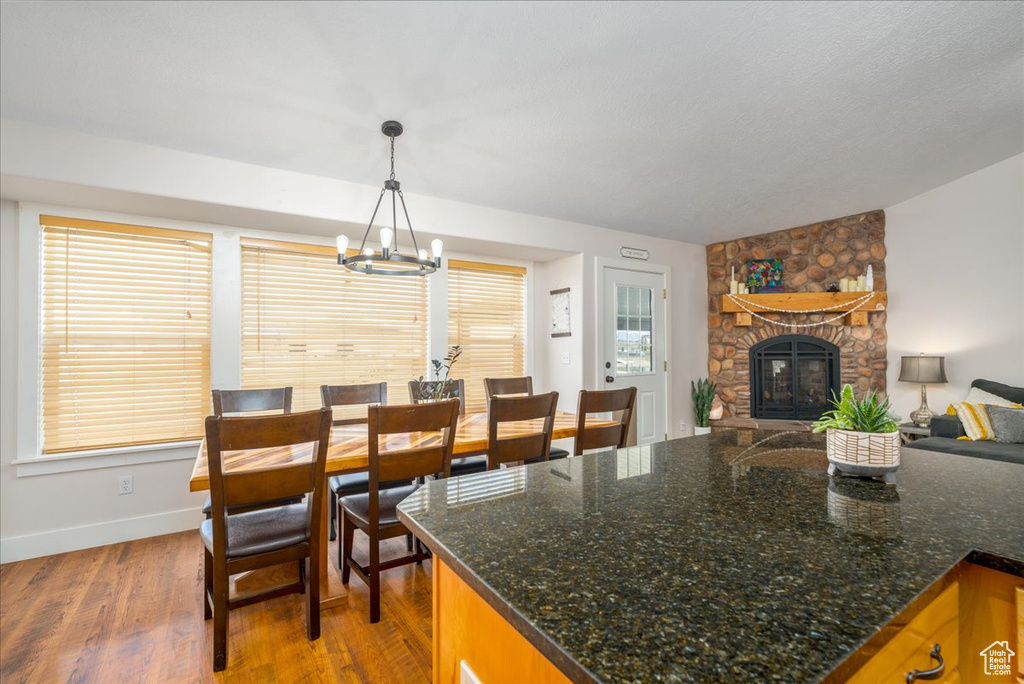 Interior space featuring a fireplace, a notable chandelier, a textured ceiling, and hardwood / wood-style floors