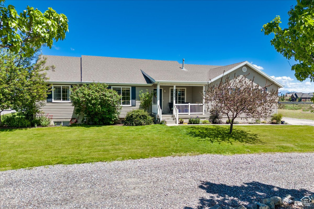 View of front of property featuring a front lawn and covered porch