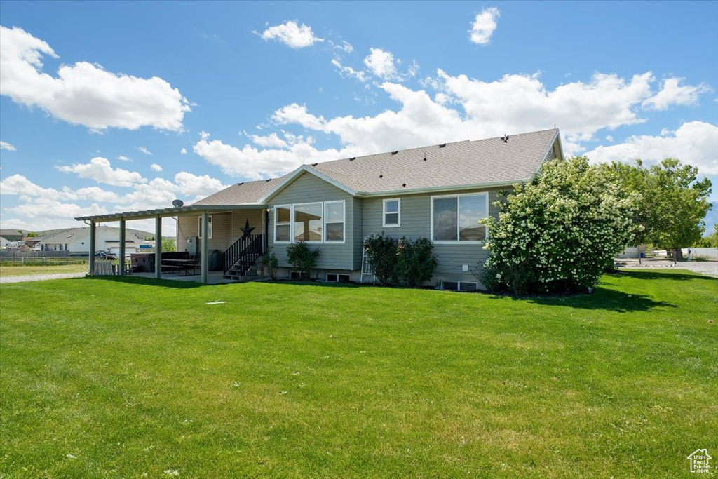 Rear view of house featuring a lawn