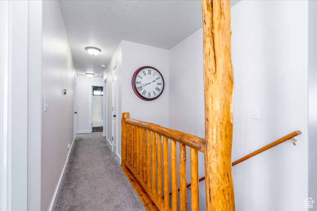 Hall featuring carpet and a textured ceiling