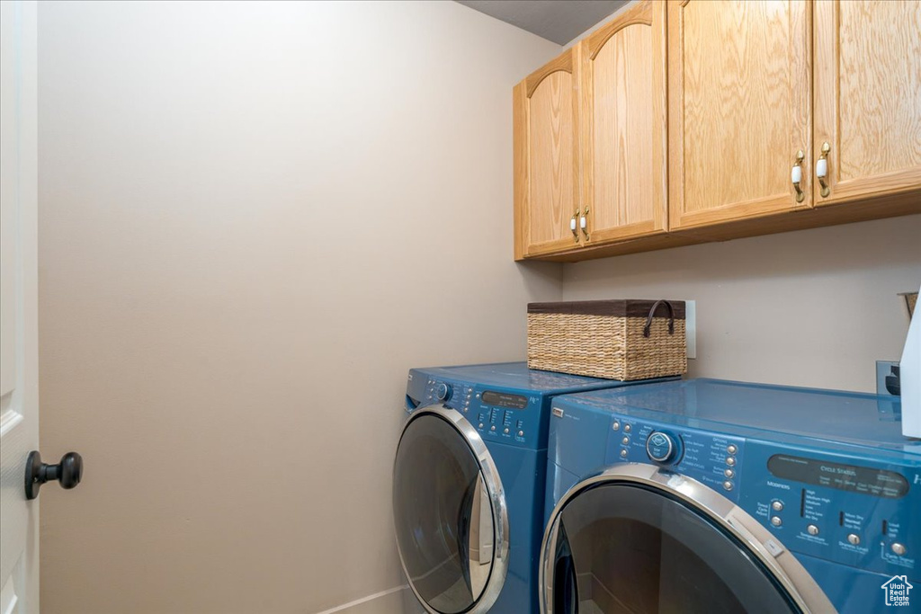 Laundry room featuring cabinets and washer and clothes dryer