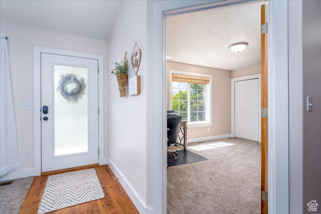 Carpeted entrance foyer with a textured ceiling