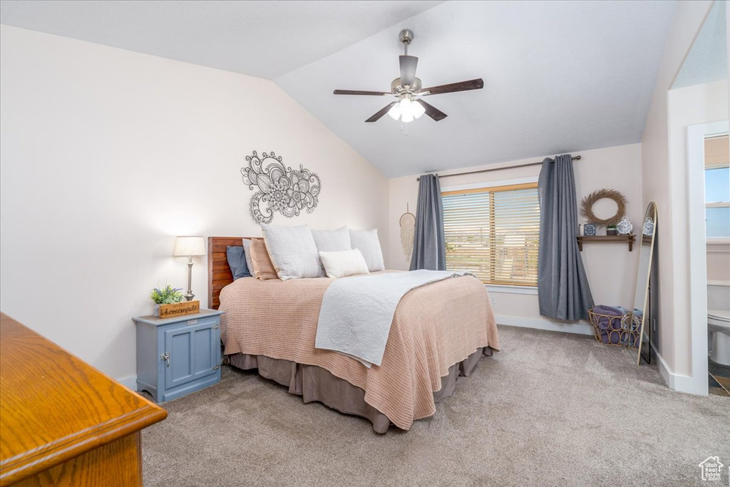 Bedroom with light colored carpet, vaulted ceiling, and ceiling fan