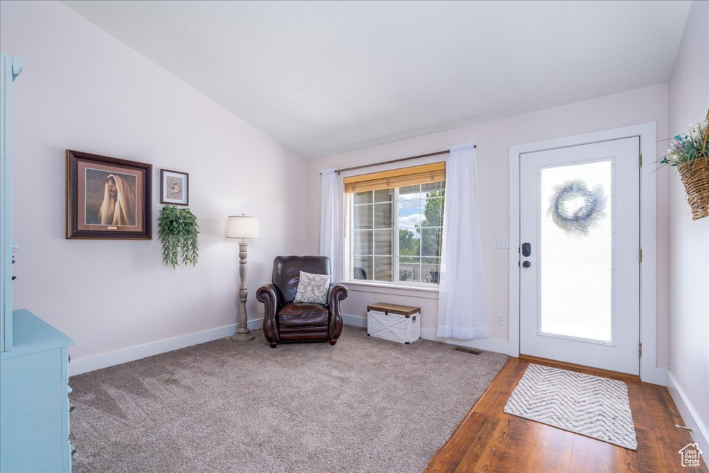 Foyer with hardwood / wood-style floors and lofted ceiling