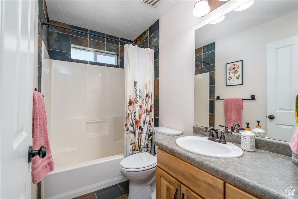 Full bathroom with shower / bathtub combination with curtain, oversized vanity, toilet, and tile floors