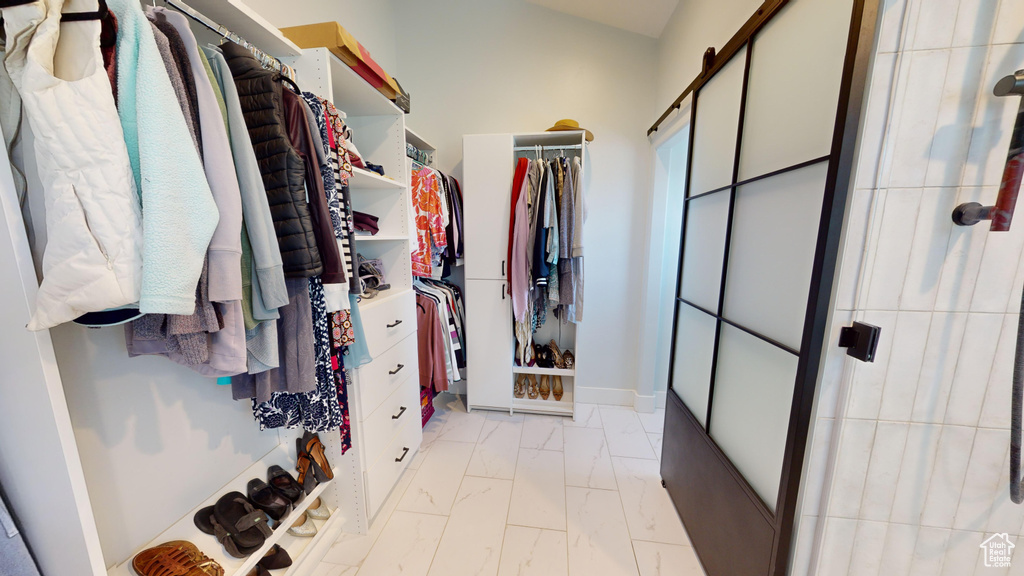 Walk in closet featuring light tile floors