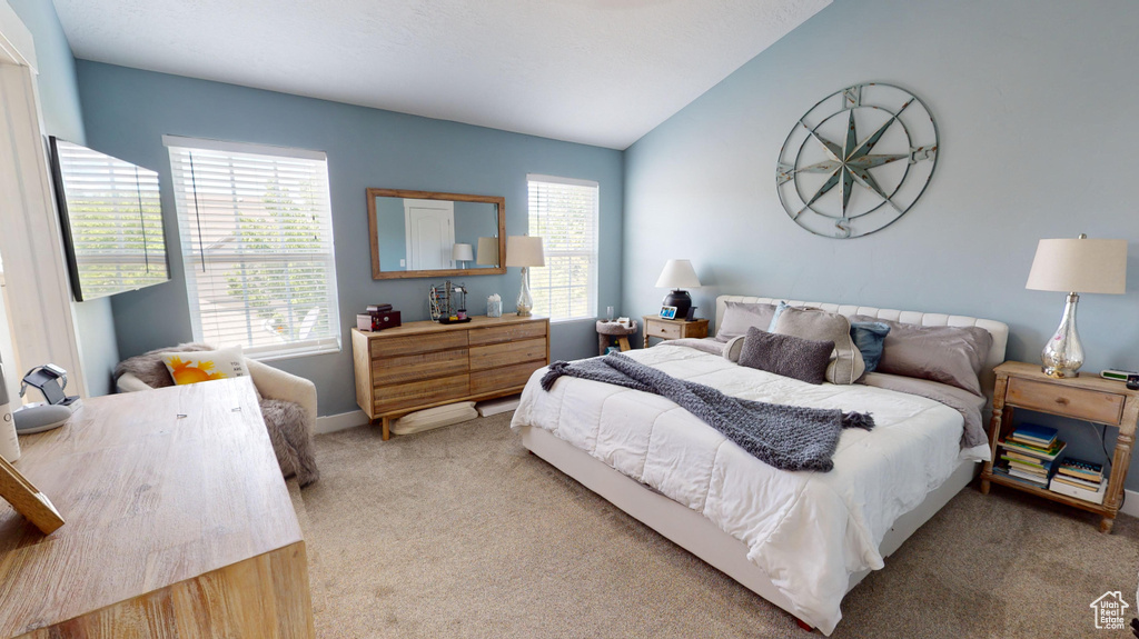 Bedroom with vaulted ceiling and carpet floors