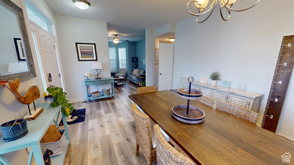 Dining room featuring ceiling fan with notable chandelier and hardwood / wood-style floors