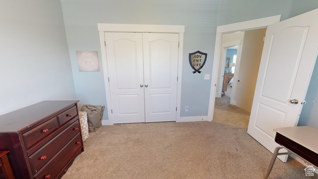 Bedroom with a closet and light colored carpet