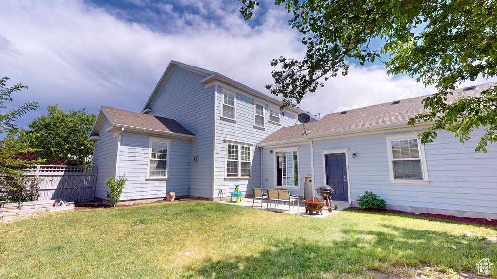 Rear view of house with a yard and a patio area