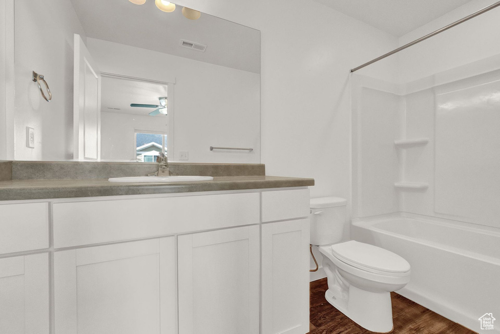 Full bathroom featuring ceiling fan, shower / bathing tub combination, wood-type flooring, vanity, and toilet