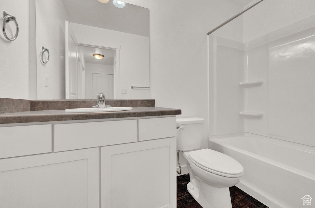 Full bathroom with shower / tub combination, hardwood / wood-style flooring, vanity, and toilet