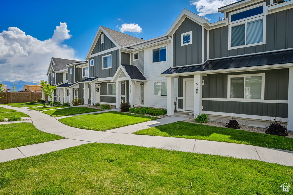 Townhome / multi-family property featuring a front lawn