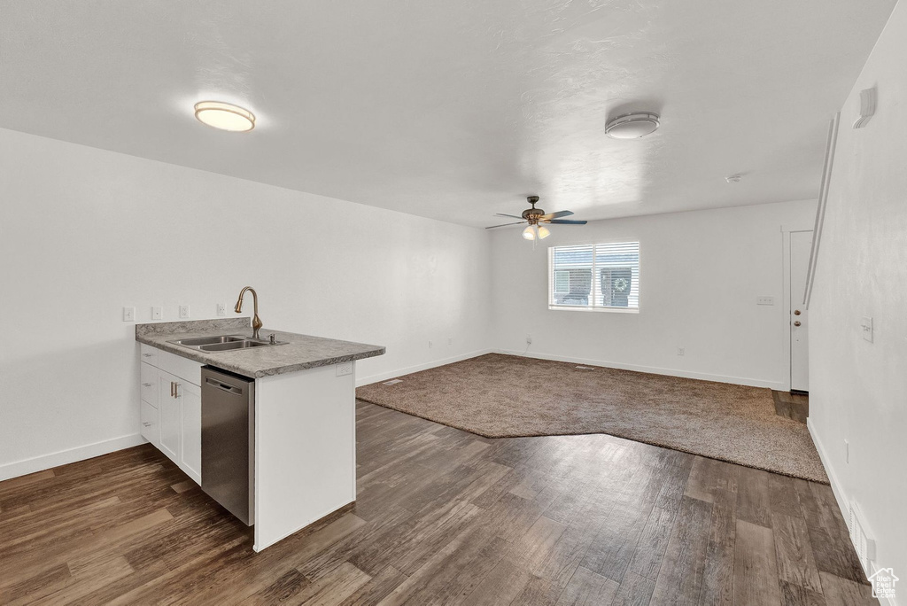 Kitchen with sink, ceiling fan, dark hardwood / wood-style flooring, and stainless steel dishwasher