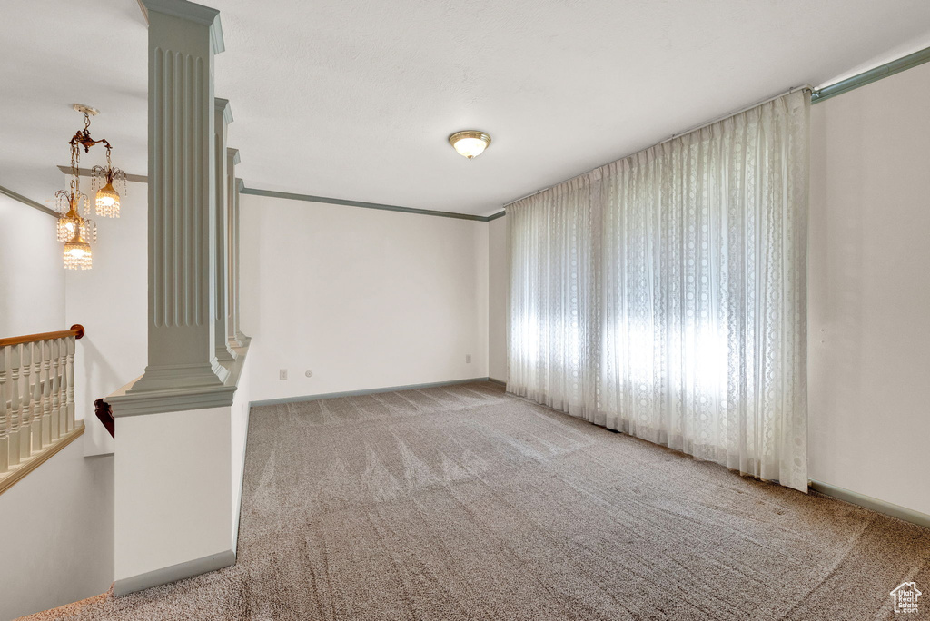 Carpeted spare room featuring ornate columns