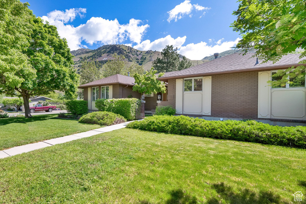 View of front of home featuring a front lawn and a mountain view