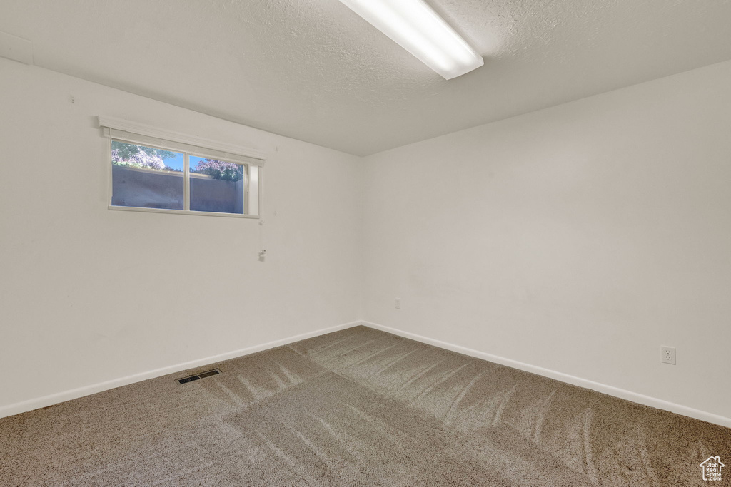 Spare room with a textured ceiling and carpet floors