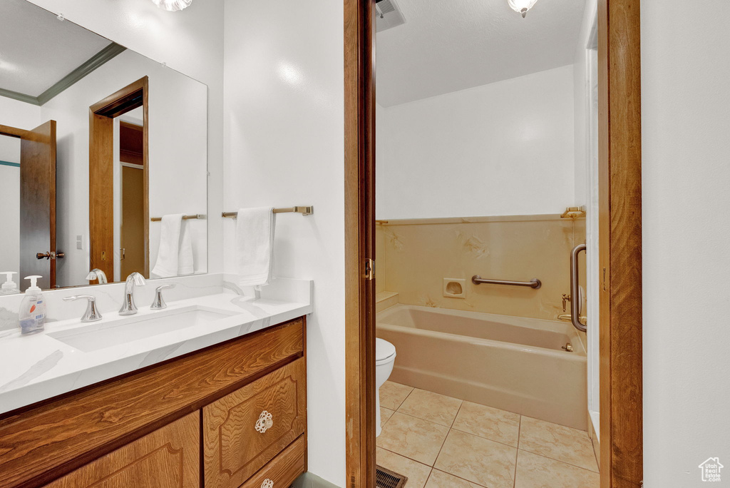 Bathroom with crown molding, toilet, oversized vanity, and tile floors