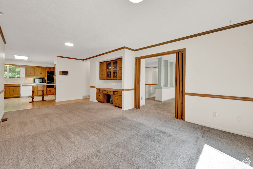 Unfurnished living room with light carpet and ornamental molding