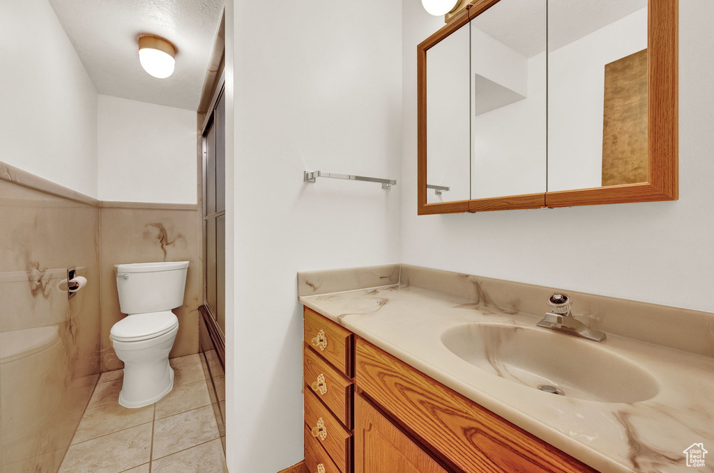 Bathroom with tile flooring, toilet, and vanity