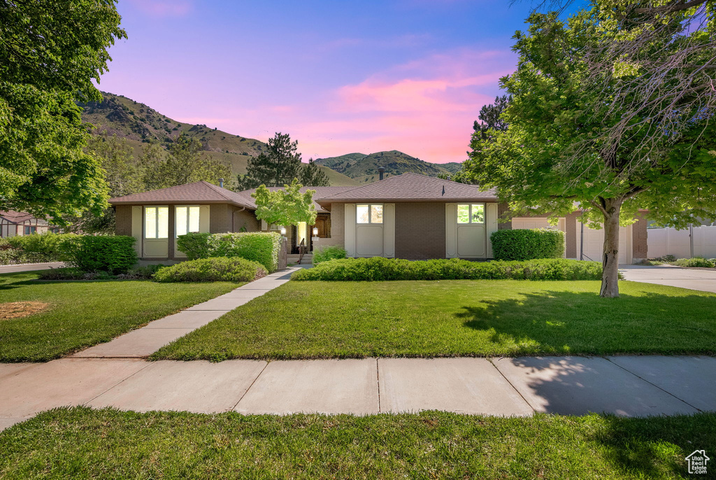 View of front of home featuring a mountain view and a yard