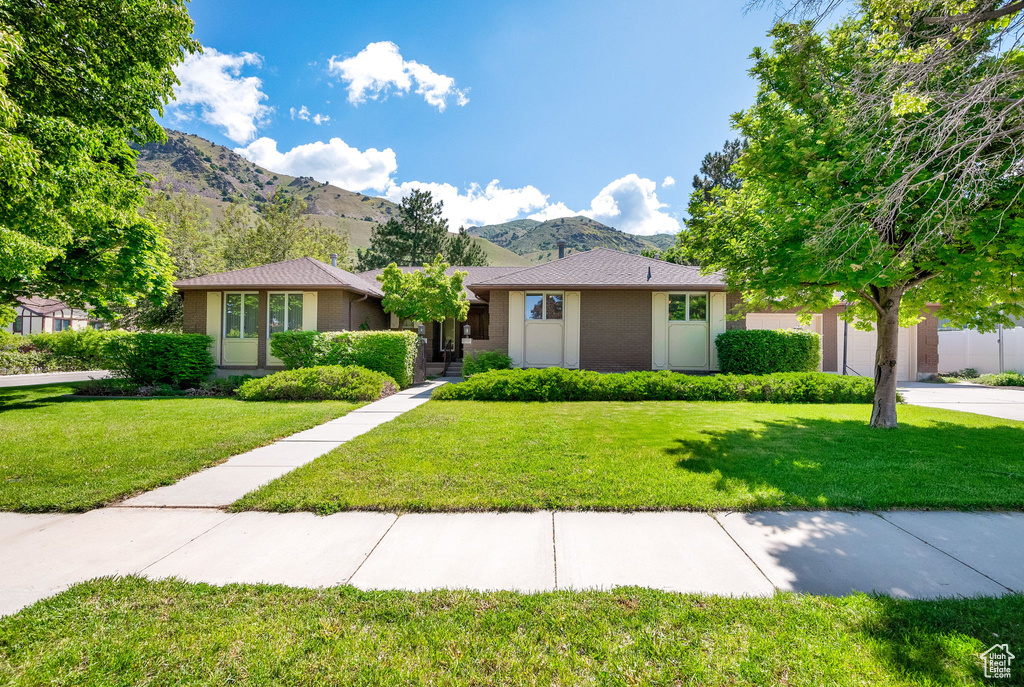 View of front of house featuring a front yard and a mountain view