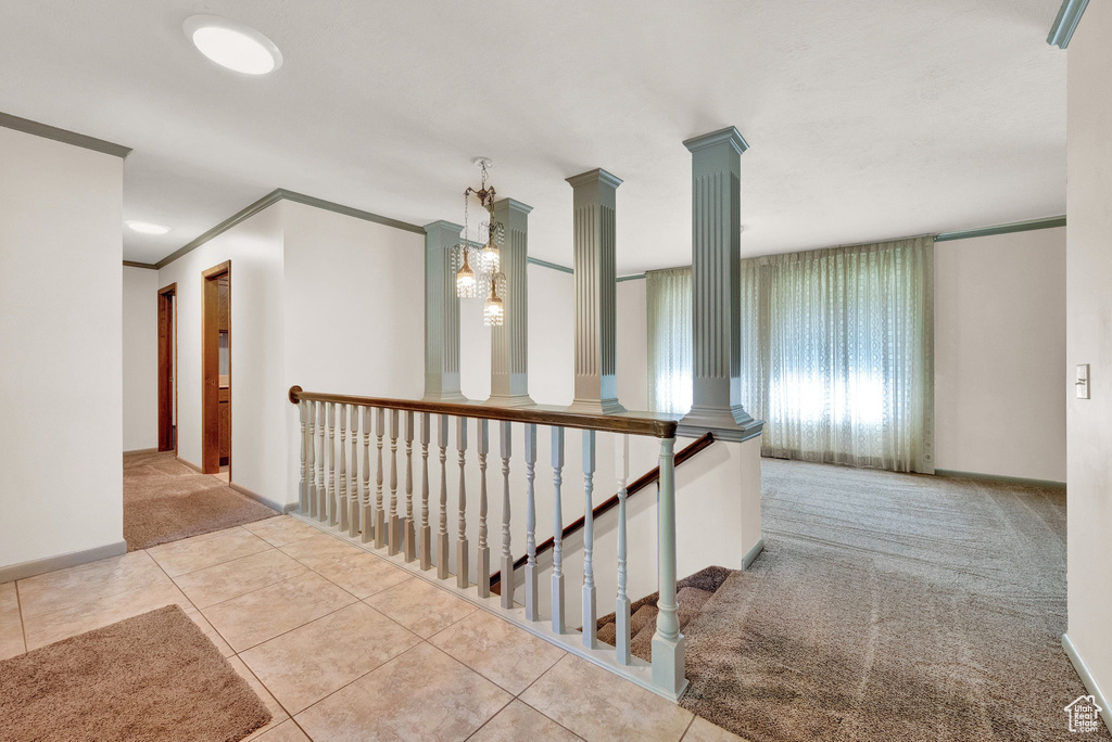 Corridor featuring crown molding, carpet flooring, and ornate columns