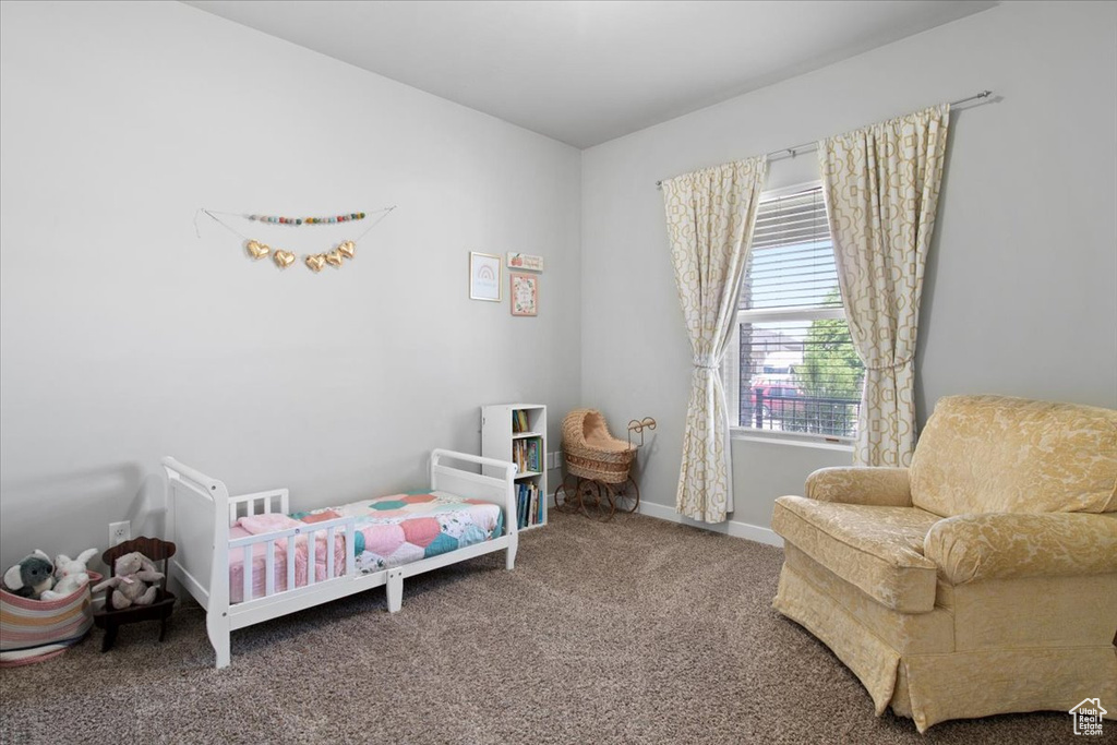 Bedroom featuring a nursery area and carpet