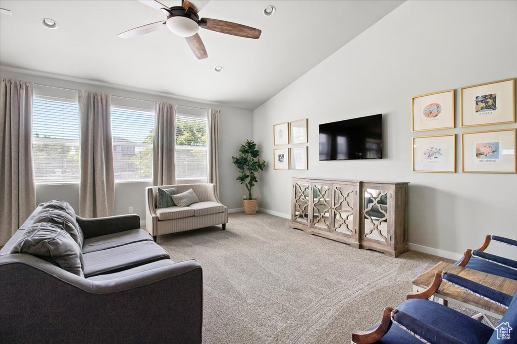 Carpeted living room featuring high vaulted ceiling and ceiling fan