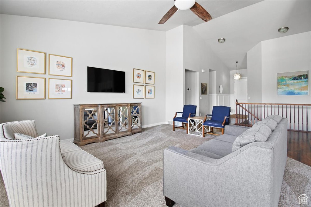 Carpeted living room featuring high vaulted ceiling and ceiling fan