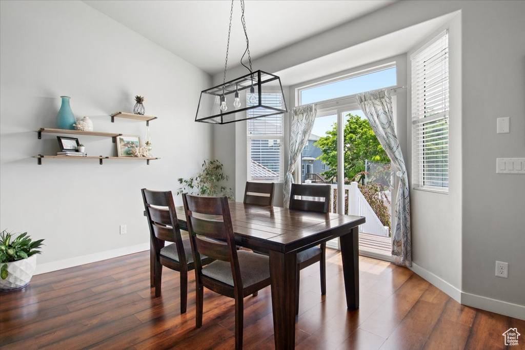 Dining space with a chandelier and dark wood-type flooring