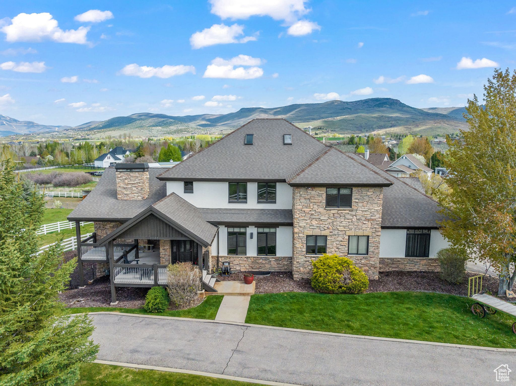 Rear view of property with a lawn and a mountain view