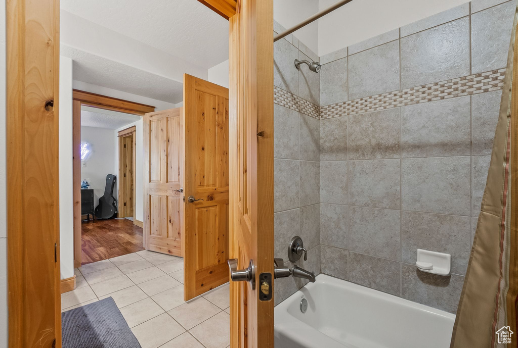 Bathroom featuring tile floors and shower / bath combination with curtain