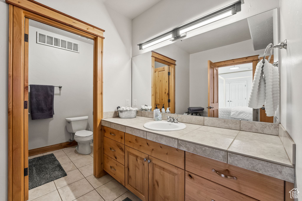 Bathroom with tile flooring, vanity, and toilet