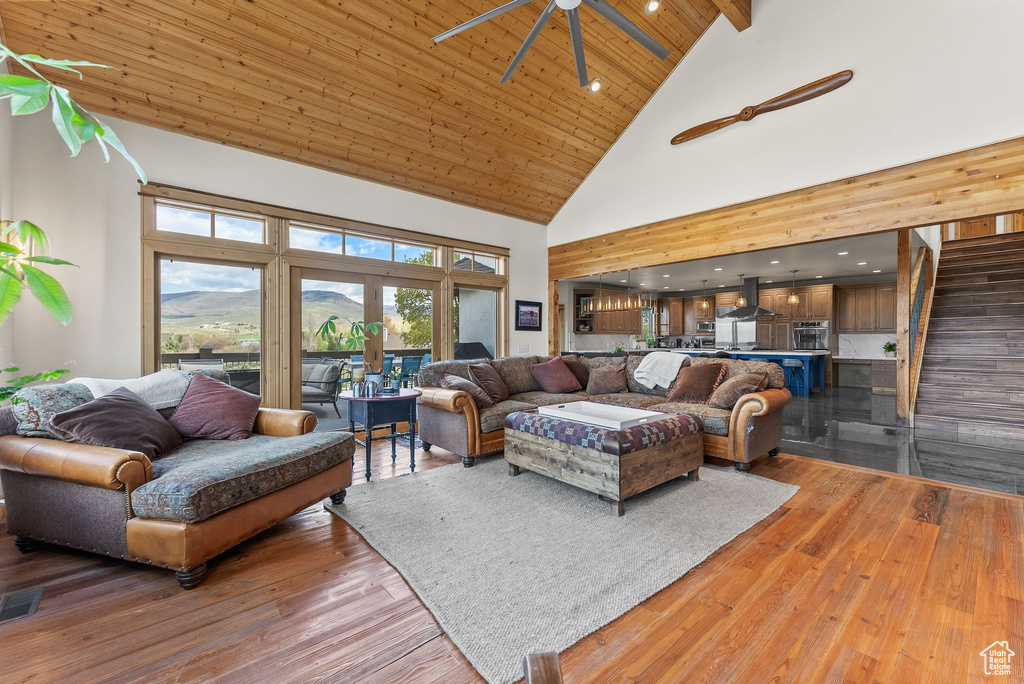 Living room with high vaulted ceiling, wood ceiling, ceiling fan, and hardwood / wood-style floors