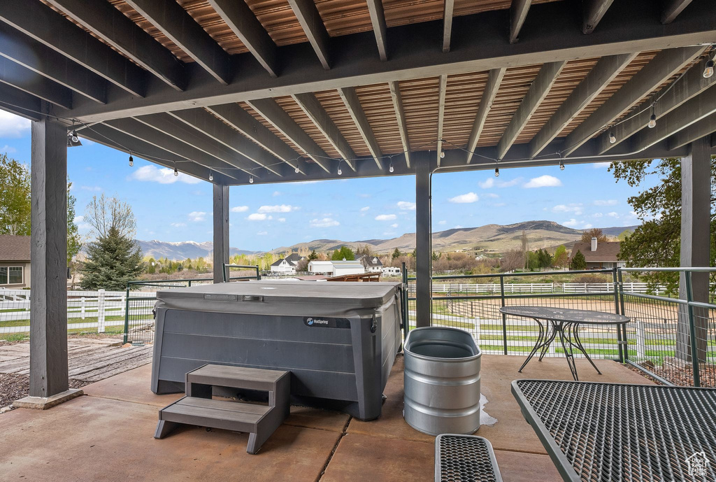 View of patio featuring a mountain view and a hot tub