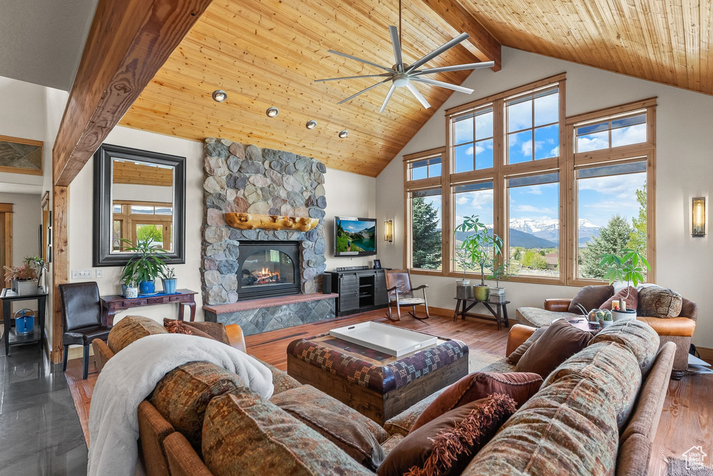 Living room with a fireplace, ceiling fan, wooden ceiling, hardwood / wood-style floors, and beamed ceiling