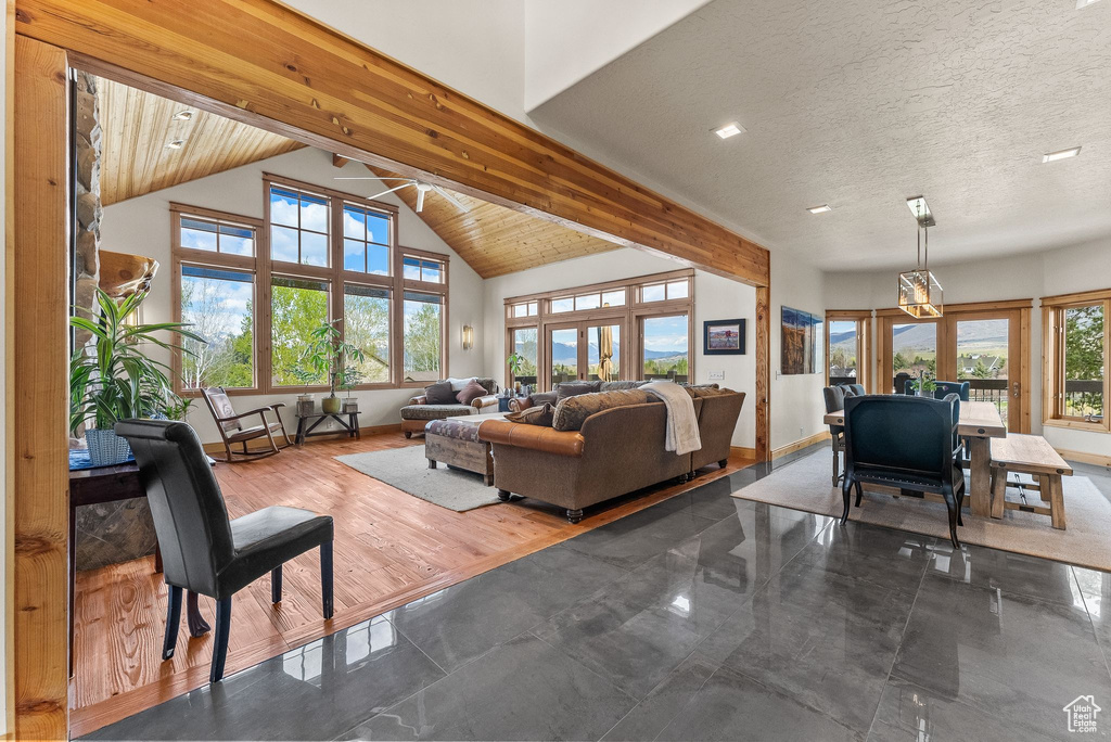 Tiled living room featuring a wealth of natural light, beamed ceiling, and high vaulted ceiling