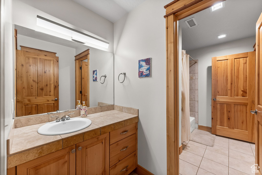 Bathroom featuring tile floors, shower / tub combo with curtain, and vanity